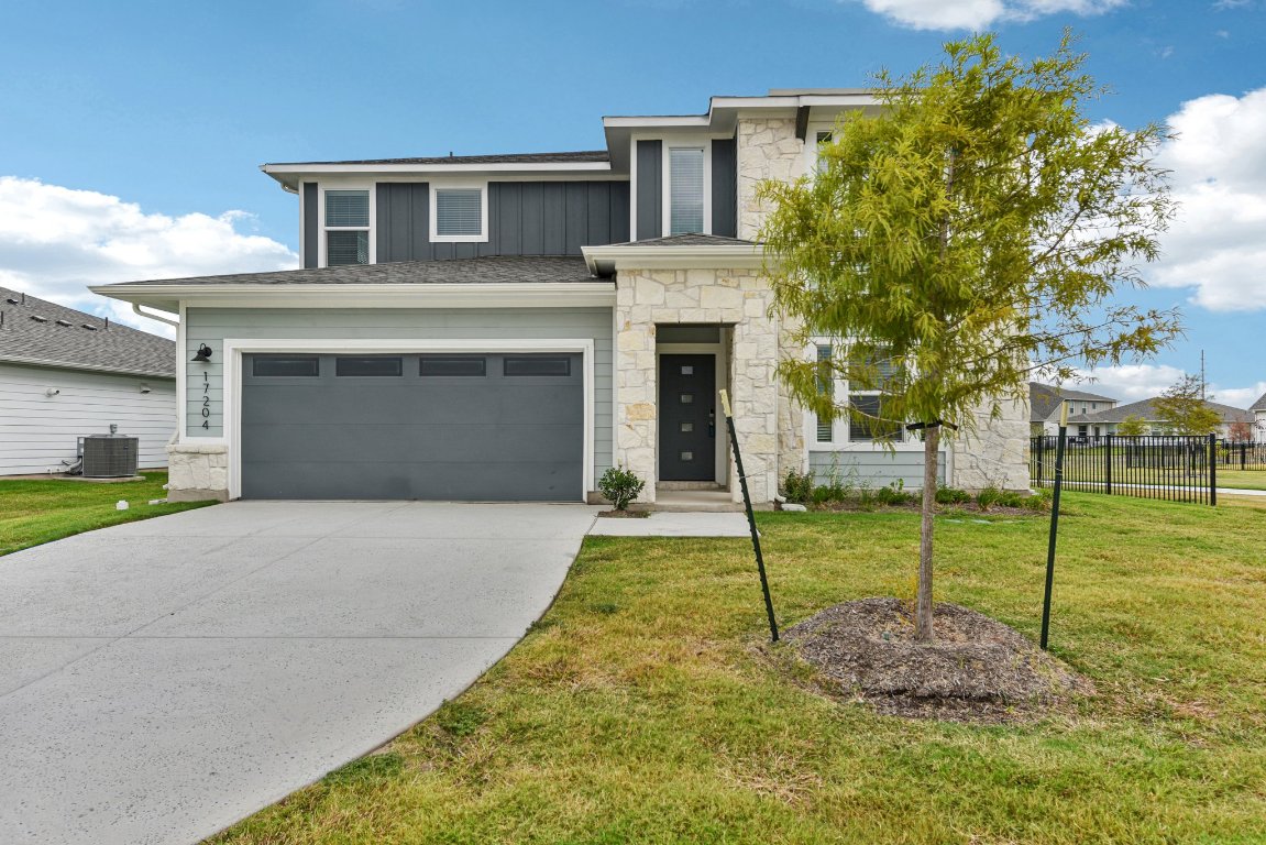 17204 Lomond Way Pflugerville, TX 78660 - Photo 1 of 1 View of front facade with stone siding, board and batten siding, an attached garage, and concrete driveway
