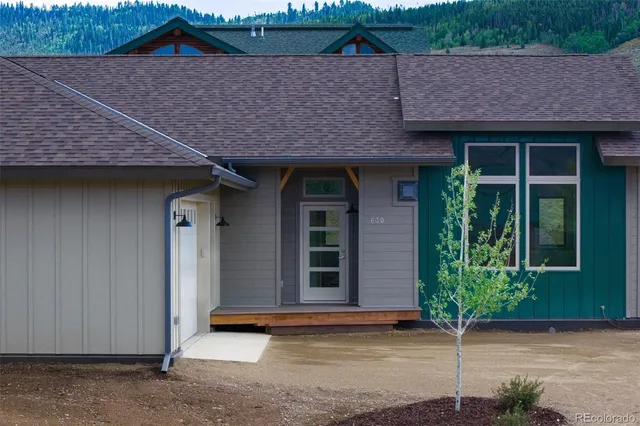 a aerial view of a house with table and chairs under an umbrella