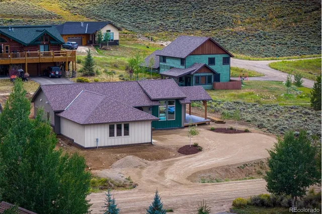 an aerial view of a house with a garden and lake view