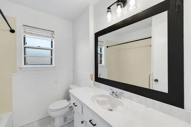 a bathroom with a bathtub a window and a shower