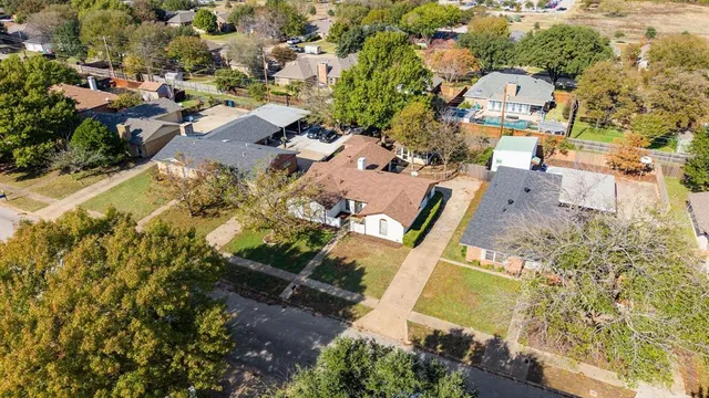 an aerial view of a residential houses with yard