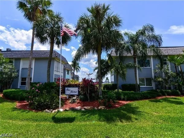 a view of a house with a yard and palm trees