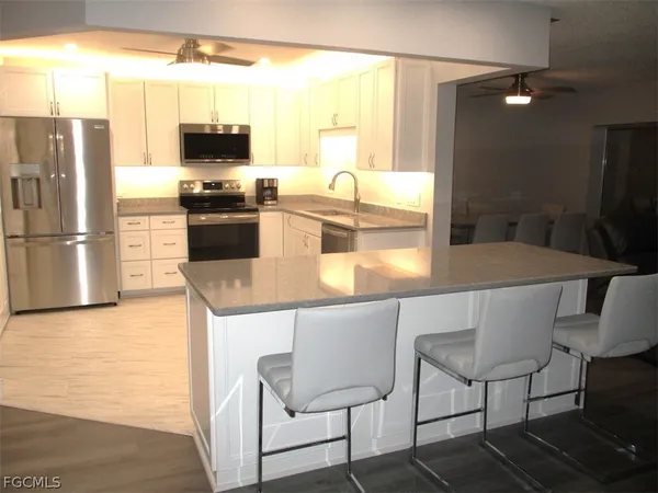 a kitchen with a table chairs refrigerator and microwave