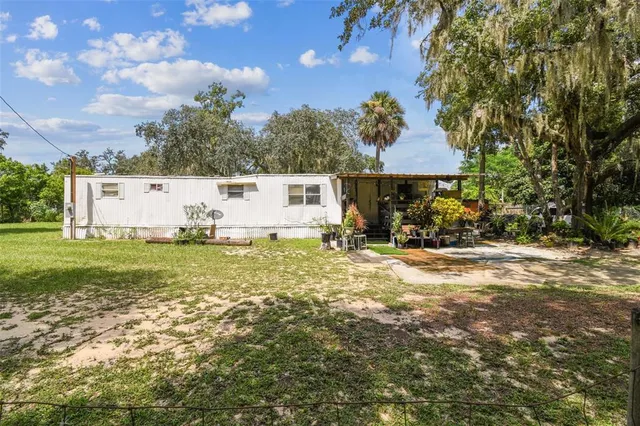 a view of a house with backyard and sitting area