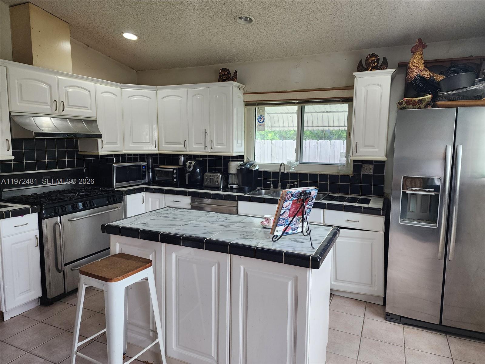 2623 Harding Street Hollywood, FL 33020 - Photo 7 of 12 a kitchen with stainless steel appliances granite countertop a sink stove and refrigerator