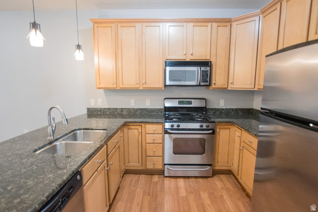 2150 South Main Street, Unit R405 Salt Lake City, UT 84115 - Photo 10 of 20 Kitchen featuring wood-finish flooring, light wood cabinetry, stone countertops, stainless steel appliances, and a double basin sink with a gooseneck faucet