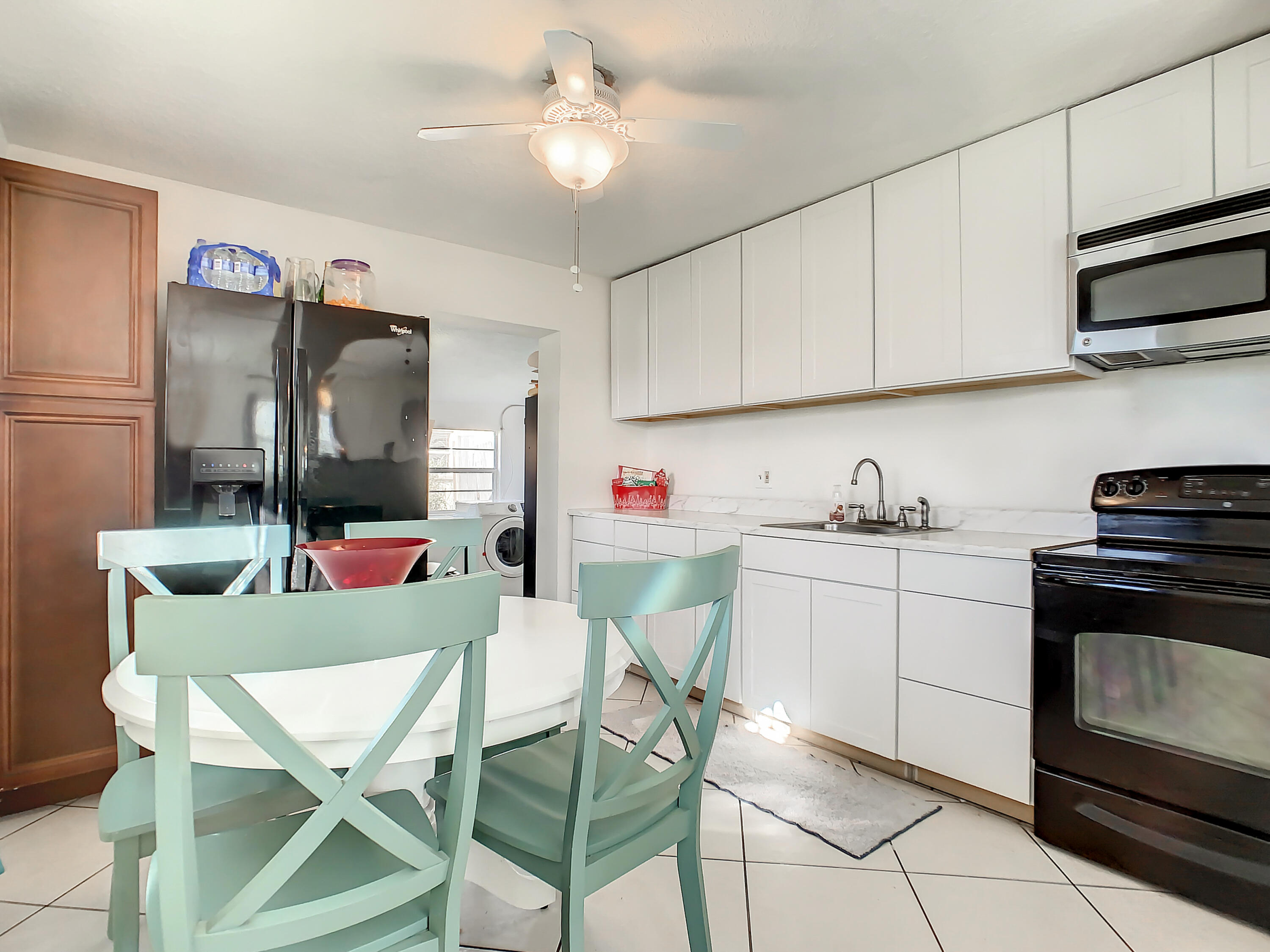 1956 Nottingham Road Melbourne, FL 32935 - Photo 9 of 32 a kitchen with stainless steel appliances kitchen island granite countertop a refrigerator a stove a microwave oven a sink with island and chairs