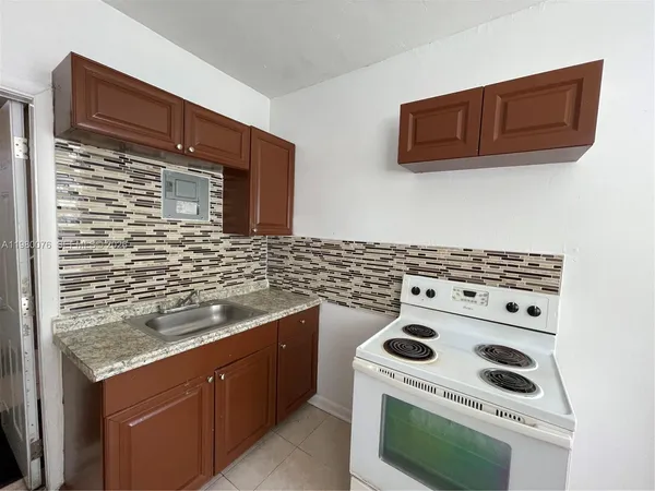 a kitchen with granite countertop a stove and a microwave