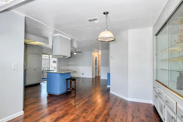 a kitchen with stainless steel appliances granite countertop a sink a refrigerator and a wooden floor