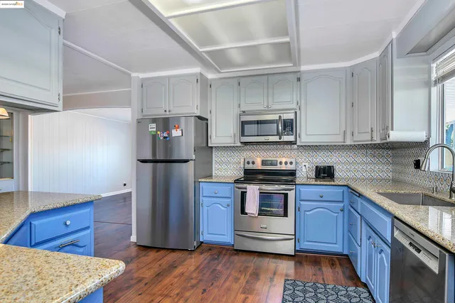 a kitchen with stainless steel appliances granite countertop a refrigerator and a stove top oven