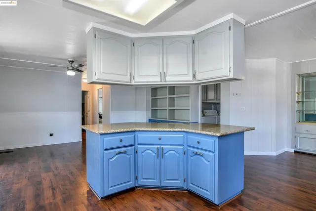 a kitchen with cabinets and wooden floor