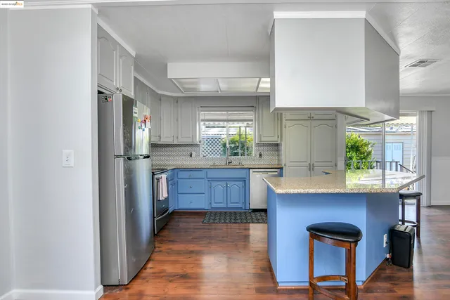 a kitchen with stainless steel appliances granite countertop a refrigerator and a stove