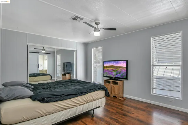 a bedroom with a bed and a flat screen tv