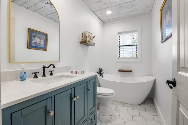 a bathroom with a double vanity sink mirror and bathtub