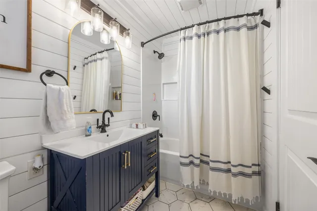 a bathroom with a sink a mirror a vanity and a shower