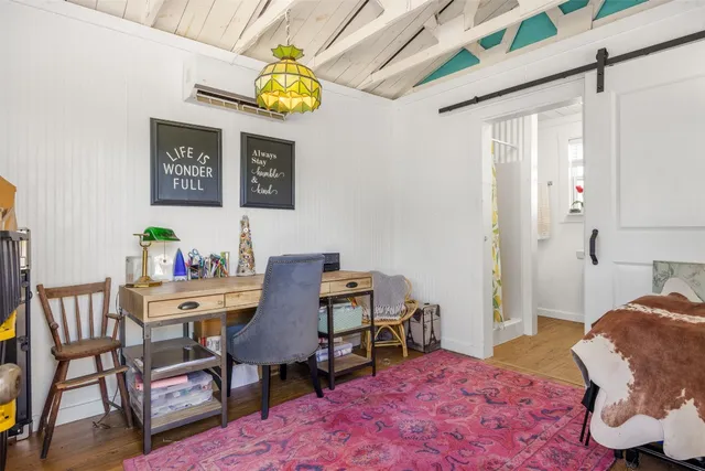 a bedroom with a bed a computer on a desk and chair