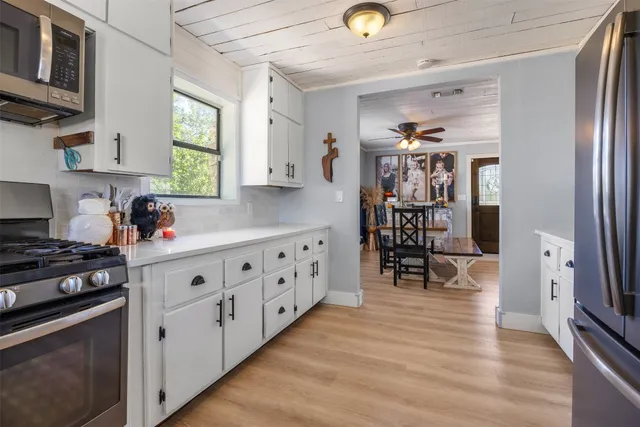 a kitchen with cabinets a window and stainless steel appliances