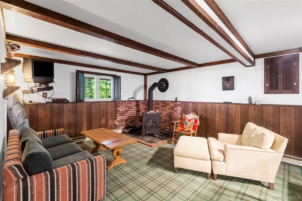 a living room with furniture a flat screen tv and a floor to ceiling window