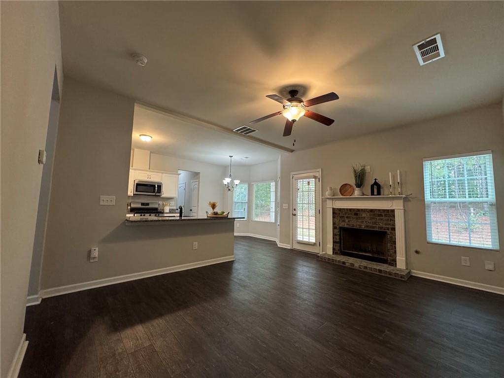 98 Baywood Way Hiram, GA 30141 - Photo 8 of 55 a view of a kitchen with a stove wooden cabinet a fireplace a ceiling fan and wooden floor
