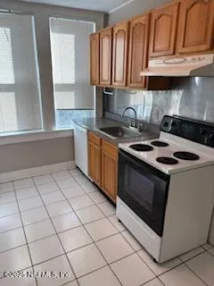 a kitchen with granite countertop a stove a sink and a microwave
