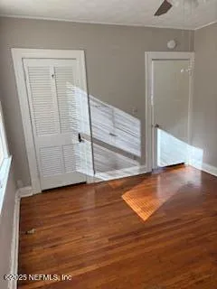 an empty room with wooden floor and closet