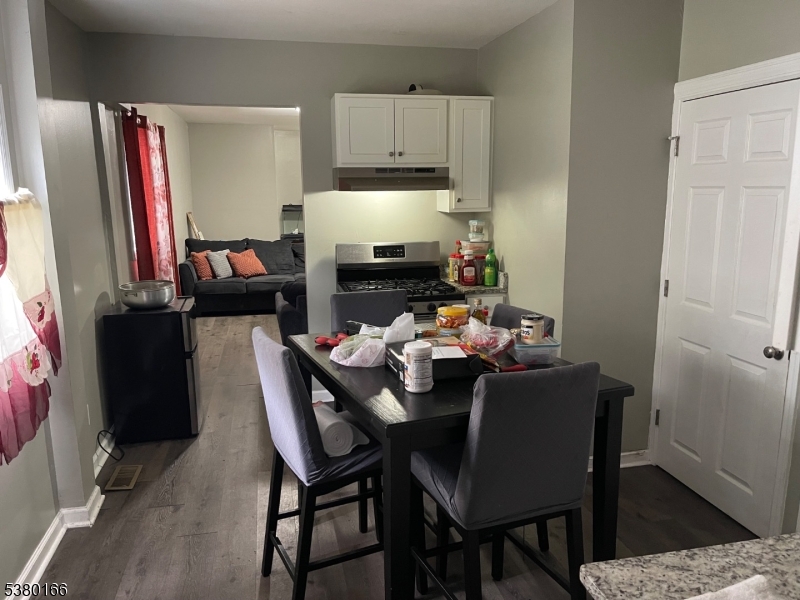162 Lyon Street Paterson, NJ 07524 - Photo 25 of 25 a kitchen with a dining table and chairs with wooden floor
