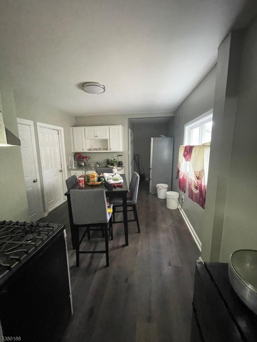 162 Lyon Street Paterson, NJ 07524 - Photo 9 of 25 a open kitchen with stainless steel appliances granite countertop a stove top oven a refrigerator a dining table and chairs with wooden floor