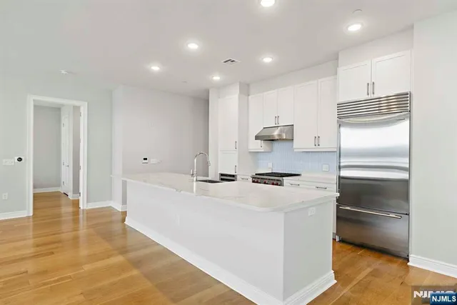 a kitchen with kitchen island a sink appliances and cabinets