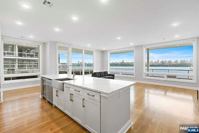 a large white kitchen with sink and cabinets