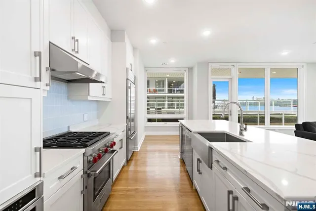 a kitchen with stainless steel appliances a sink stove and cabinets