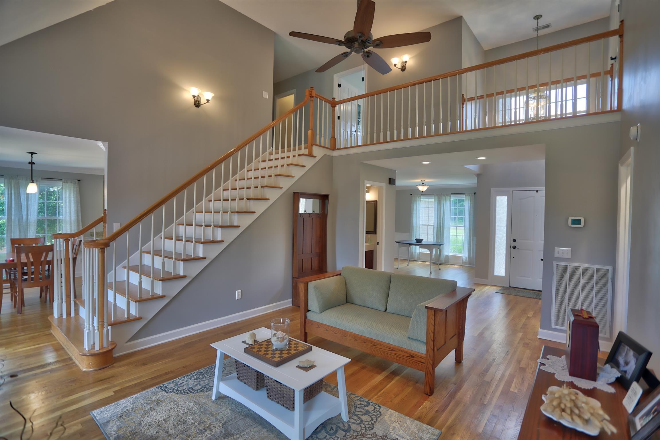 7288 Old Franklin Road Fairview, TN 37062 - Photo 2 of 30 The living room has a vaulted ceiling and stairs leading to a railed landing.