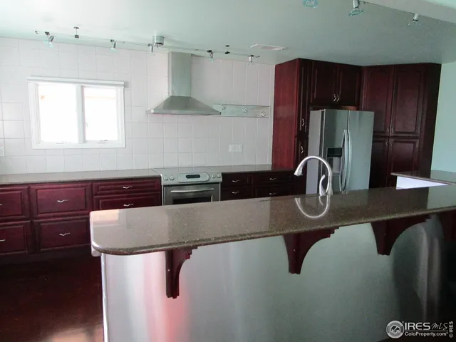 a kitchen with stainless steel appliances granite countertop a sink refrigerator and cabinets