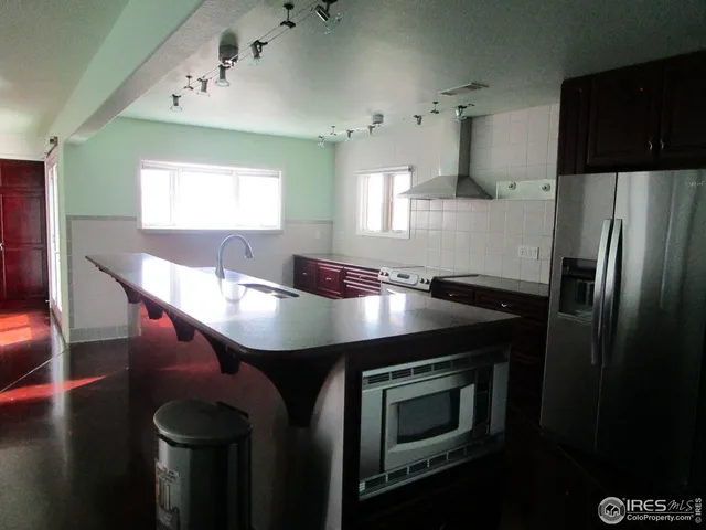 a kitchen with stainless steel appliances kitchen island a sink refrigerator and microwave