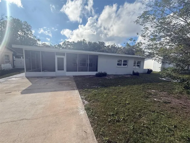 a view of a house with a yard and pathway