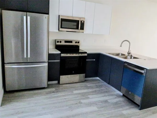 a kitchen with stainless steel appliances granite countertop a refrigerator stove a sink and dishwasher