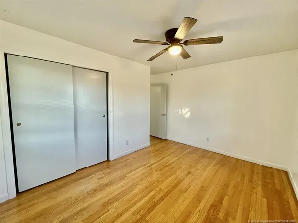 a view of empty room with wooden floor