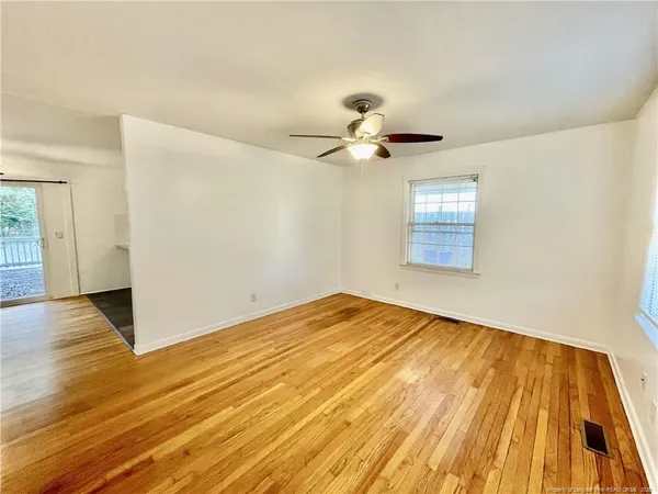 a view of empty room with wooden floor