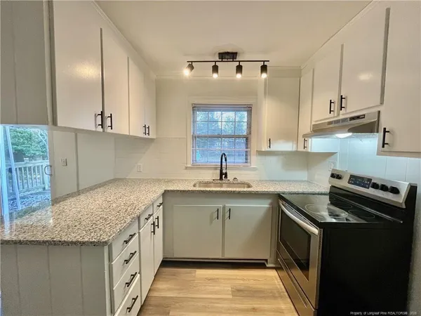 a kitchen with a sink stove and cabinets