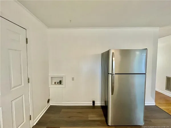 a view of a refrigerator in kitchen and white cabinets
