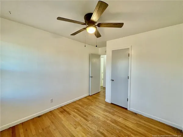 a view of empty room with wooden floor