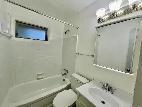 a bathroom with a sink mirror toilet and bathtub