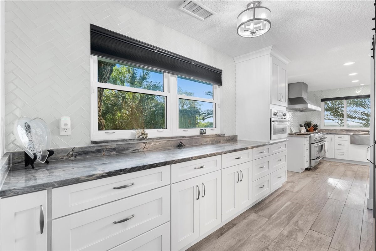 85316 Avant Road Yulee, FL 32097 - Photo 17 of 62 a kitchen with granite countertop white cabinets and a large window