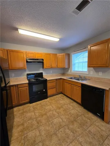 a kitchen with a sink appliances and cabinets