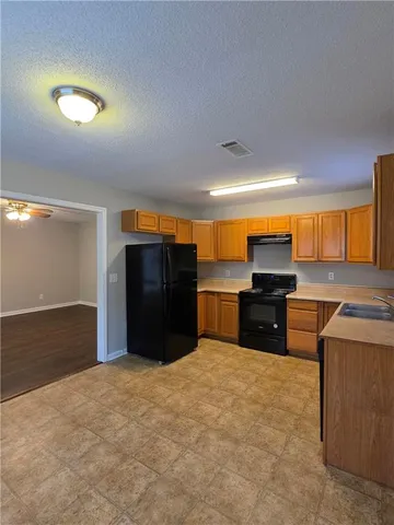 a kitchen with stainless steel appliances a refrigerator and a stove top oven