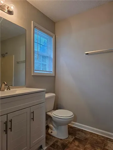 a bathroom with a toilet a sink and mirror