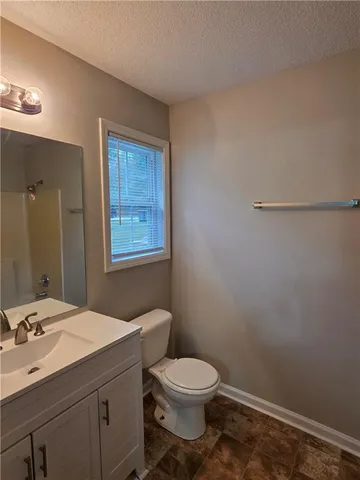 a bathroom with a toilet a sink and mirror