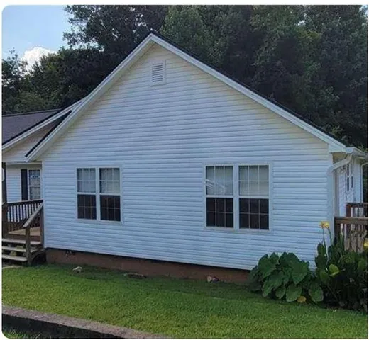 a view of a house with a yard and potted plants