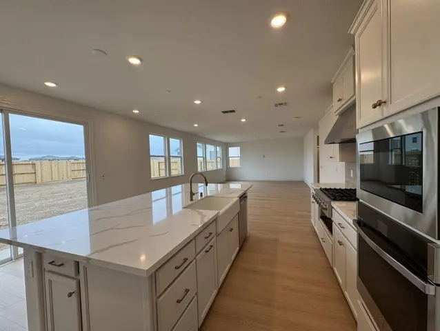 a large kitchen with stainless steel appliances a large counter top