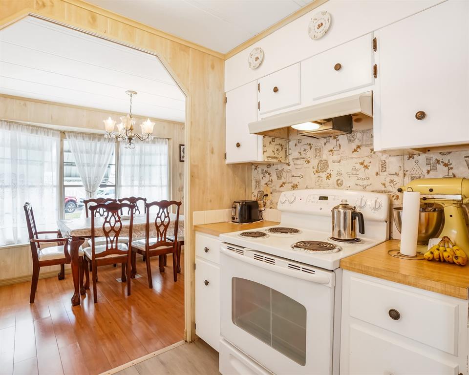 8517 Southwest 16th Place Davie, FL 33324 - Photo 18 of 28 a kitchen with a stove a sink and white cabinets with wooden floor