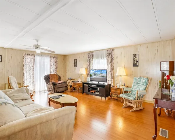a living room with furniture fireplace and a large window